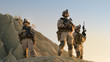 © Gorodenkoff - Squad of Three Fully Equipped and Armed Soldiers Standing on Hill in Desert Environment in Sunset Light.