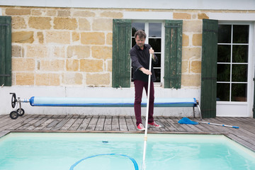 Wall Mural - Man cleaning the swimming pool