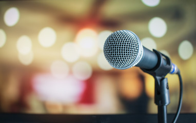 microphone for speaker on abstract blurred of speech in seminar room or speaking conference for audi