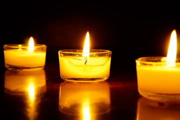 Candles light flame on low light background.