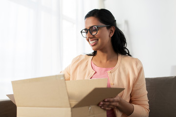 happy young indian woman with parcel box at home