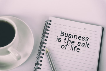 Wall Mural - Inspirational quote - Business is the salt of life: written on a note pad with eyeglasses and pen.