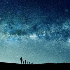 Wall Mural - silhouetted people and lights of universe