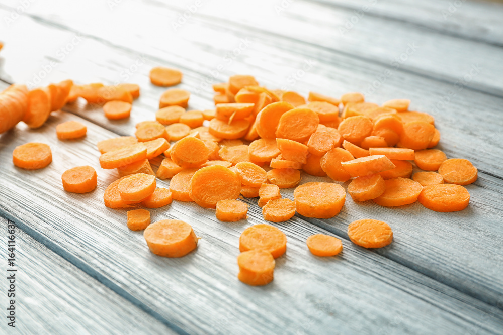 Slices of carrot on wooden background
