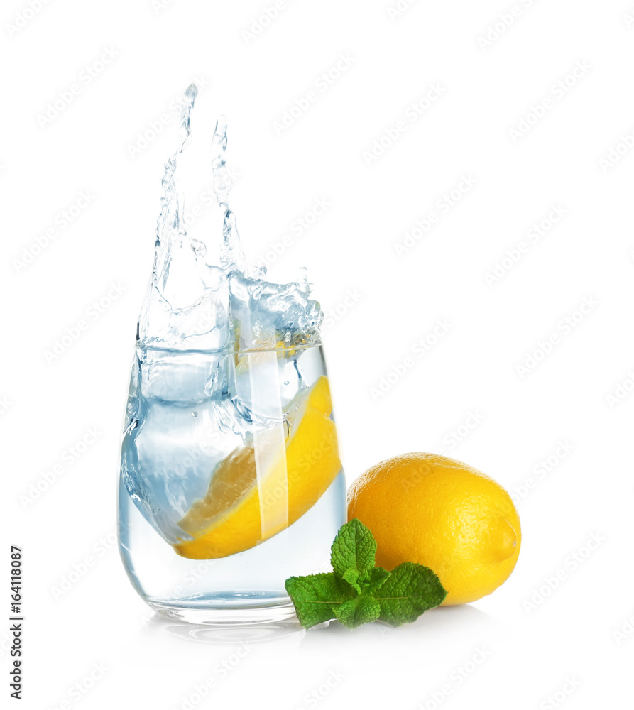 Glass of lemonade with splashing water on white background