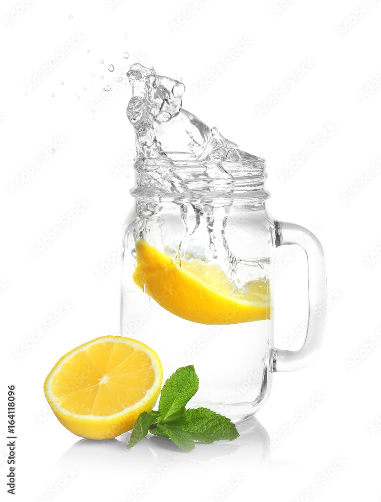 Mason jar of lemonade with splashing water on white background