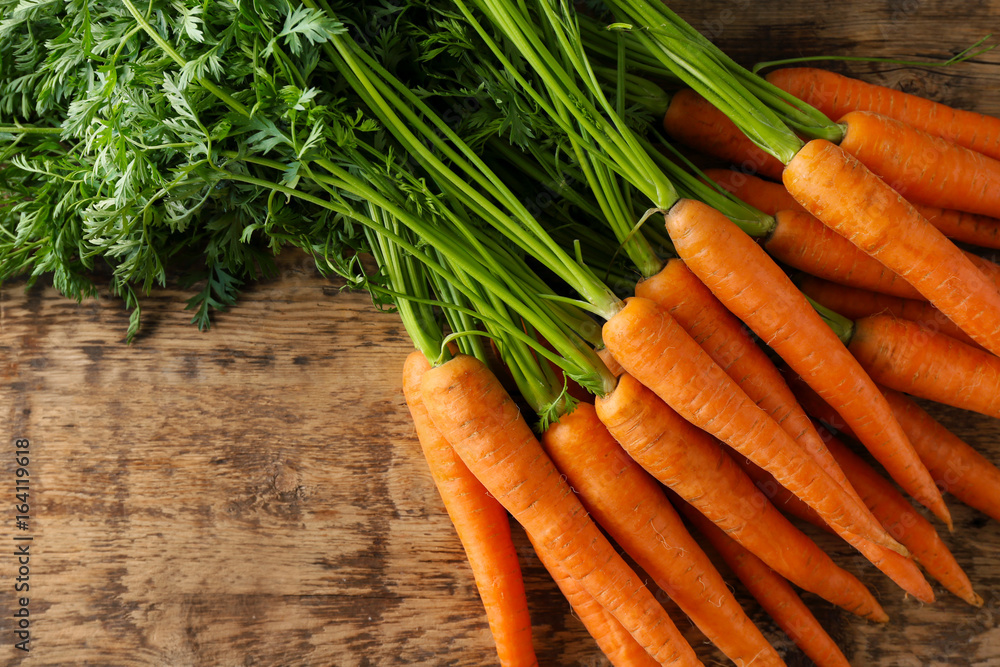 Fresh organic carrots on wooden table
