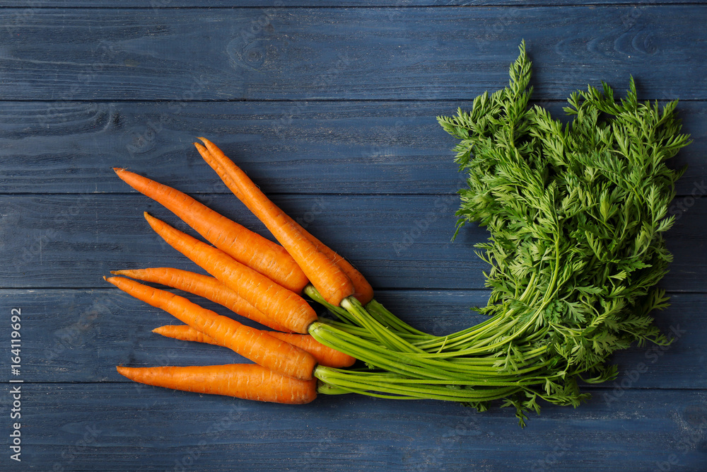 Homegrown crispy carrots on wooden color background