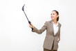 © Vittaya_25 - happy young asian business woman in suit beautiful smiling taking selfie with mobile smartphone on selfie stick isolated on white background, social media network technology and lifestyle concept