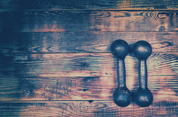 Retro grunge iron dumbbells on grunge wooden background