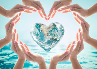 world heart day and environmental protection concept with love earth in community volunteer's hands.