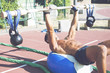 © Addoro - Handsome middle aged man working out on a running track. Healthy adult man doing push ups using a kettlebell and wooden barbell on the yoga ball. Tanned skin and shirtless middle-aged man.