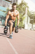 © Addoro - Crossfit training. Fitness man doing a weight training by lifting kettlebell. Midleaged athlete doing kettlebell step ups. Bodybuilder lifting kettlebell. Crossfit instructor at the track.