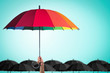 Life-health Insurance protection or business financial leadership concept with leader's hand holding rainbow umbrella on blue sky 