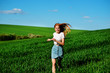 © cezarksv - Young beautiful woman running on a green field