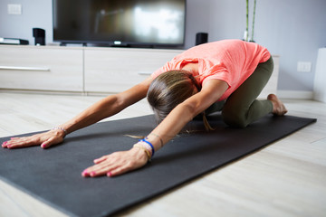 Ragazza abbigliamento sportivo fa stretching a casa