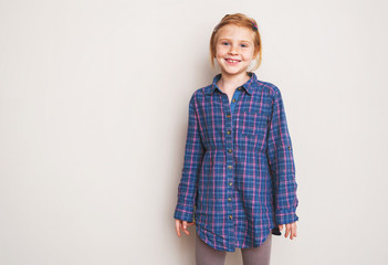 Portrait of happy redhead little girl smiling.