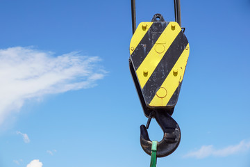 Big yellow construction crane on blue sky background