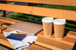 © LIGHTFIELD STUDIOS - Close-up view of laptop, passports with tickets, map and disposable coffee cups on wooden bench
