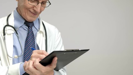 Wall Mural - Elderly doctor writing in a clipboard