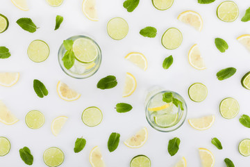  flat lay with refreshing lemonades, limes, lemons and mint leaves isolated on white