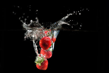 Wall Mural - Strawberries splashing into water