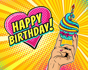 Pop art background with female hand holding cupcake with burning candle and speech bubble in form of heart with Happy Birthday text. Vector illustration in retro comic style. Party invitation poster.