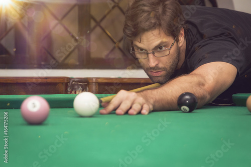 Zdjęcie XXL Mężczyzna bawić się billiards w basenu stole.