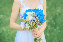 Bride Is Holding A Wedding Bouquet Of Natural Flowers