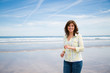 © asife - Happy middle aged woman walking on the beach