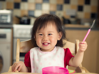 Wall Mural - baby girl eating at home