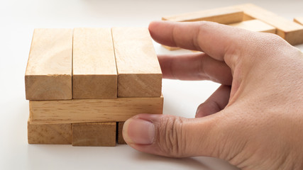 wooden block  to make structure with hand  on white background,planning in business model success