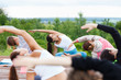 Group of people of different age yoga exercise in the park at summer. Big group of adults woman doing yoga class outdoor in nature