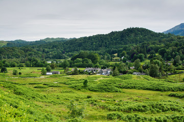 Wall Mural - Lake District National Park, England, view of the road, town, mountains on the background, selective focus