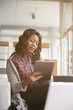 © liderina - Young business woman. African American woman typing on her tablet.