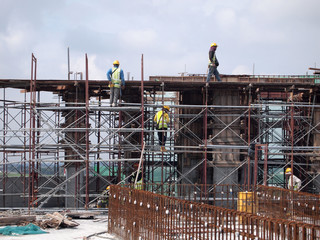 Wall Mural - Construction workers wearing safety harness and adequate safety gear while working at high level at the construction site in Seremban, Malaysia.
