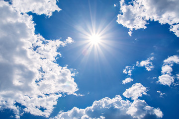 Wall Mural - sun rays against a blue sky in the clouds