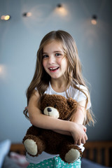 Wall Mural - Portrait of a beautiful girl with a brown toy bear