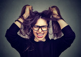 Fototapeta  - stressed angry woman pulling hair out screaming