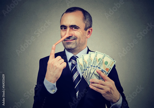 Fotografía Financial fraud concept. Liar businessman with dollar cash