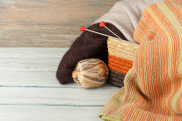 Wall Mural - Ball of wool, needles and woolen sweater with spokes for handmade knitting in basket on wooden table.