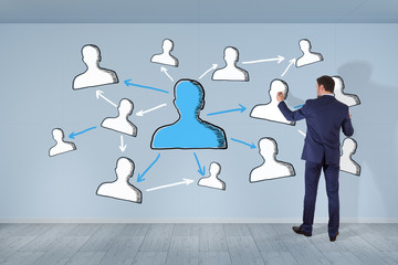 Wall Mural - Businessman drawing social network sketch on a wall 3D rendering