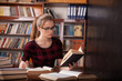© dmitriisimakov - girl student sits in the library reading
