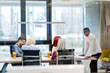 © Myvisuals - Back view of co-workers writing documents using laptops at workplace in office. Copyspace.