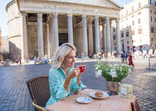 Attractive Pensive Blond Woman Drinking Italian Coffee  In The Morning And Seeting In A Street Cafe In Rome