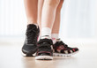 © smallblackcat - Women's and child's feet in sneakers