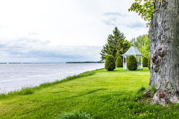 Wall Mural - Gazebo in green grass field with view of Saint Lawrence river in Quebec, Canada