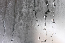 Detailed Texture Of Water Dripping Down Glass In A Humid Room.