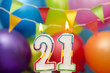 Happy Birthday number 21 celebration candle with colorful balloons and bunting