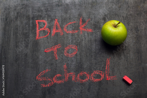 Fotografia, Obraz "back to school" inscription in red chalk on a black chalk Board and a green app